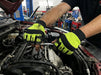 A Car Mechanic working on a car engine wearing Leather Fingerless Mechanic Glove in a garage setting.