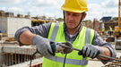Construction worker using a tool on a construction site wearing Tuff Gard H‑Power Shell NBR Cut 5 Glove
