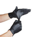 Black gloves being worn on a white background