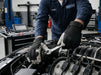 Mechanic working on a car engine in a garage wearing Tuff Gard Leather Palm Mechanic Glove – White & Black