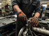 Mechanic working on a vehicle engine in a workshop wearing Tuff Gard Synthetic Leather Mechanic Glove – Fluorescent Orange & Black