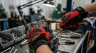 Person working on a mechanical component with tools in a workshop setting wearing  Full‑Finger Mechanic Glove
