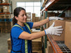 Woman in a warehouse setting, handling boxes on a rack wearing white gloves with blue trim