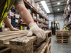 Person wearing Tuff Gard Cotton/Polyester Knit Glove on a wooden pallet in a warehouse setting